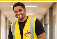 Harbor City team member in a branded vest in a clean office corridor